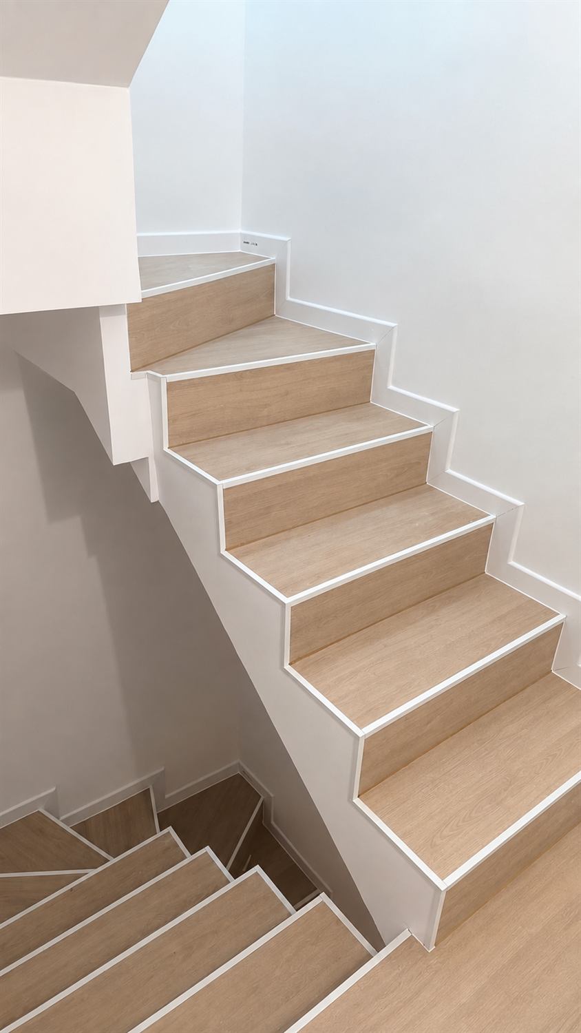 Escalera revestida con peldaños efecto madera y cantos blancos