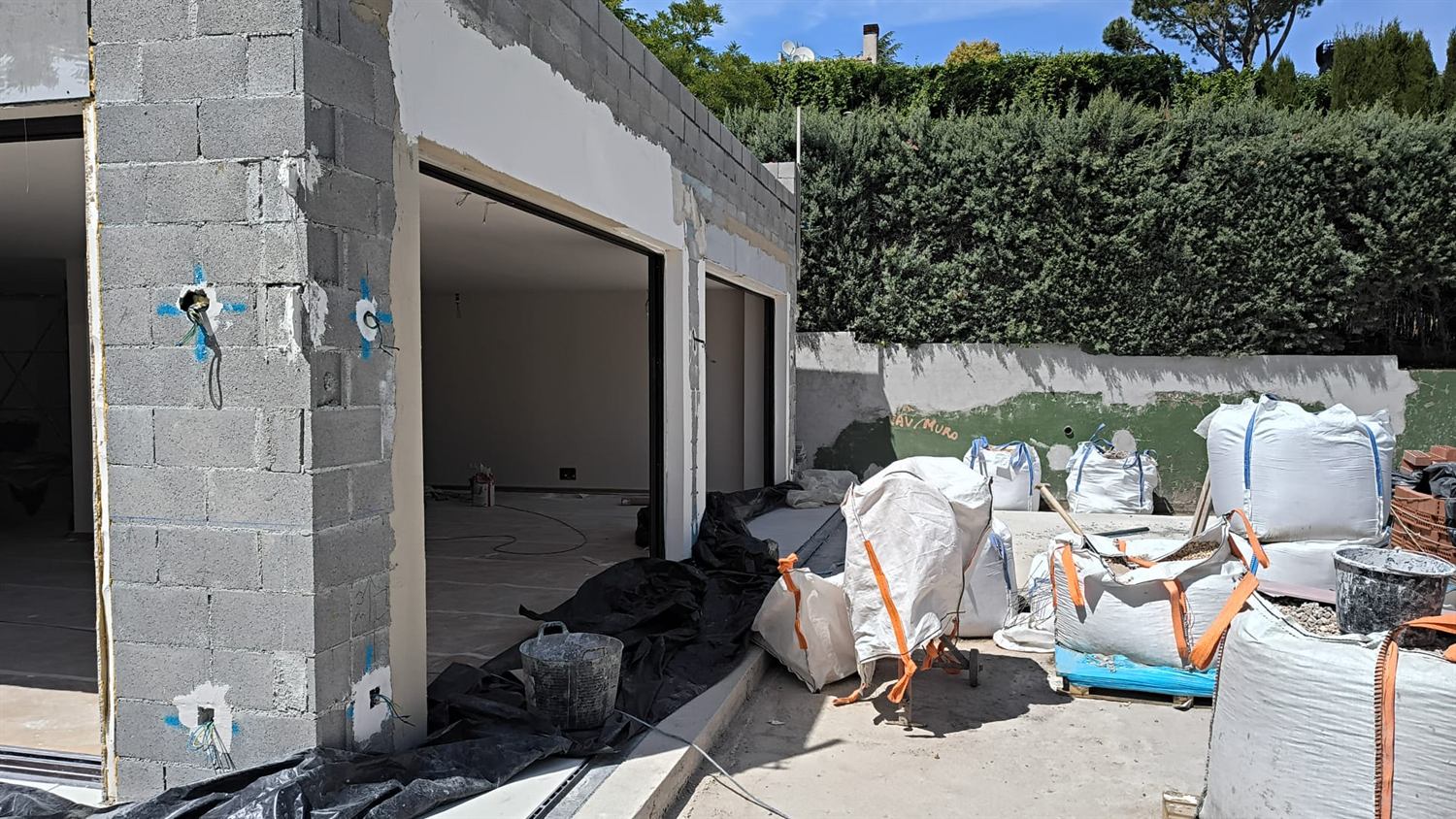Vivienda en obra con muros de bloque y grandes huecos de carpintería ya colocados