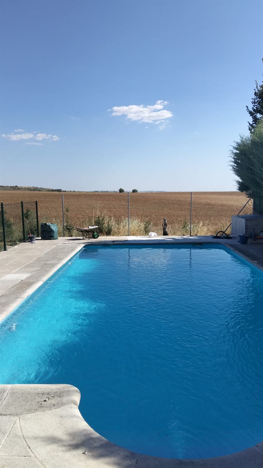 Piscina terminada con solado perimetral y vistas al campo castellano